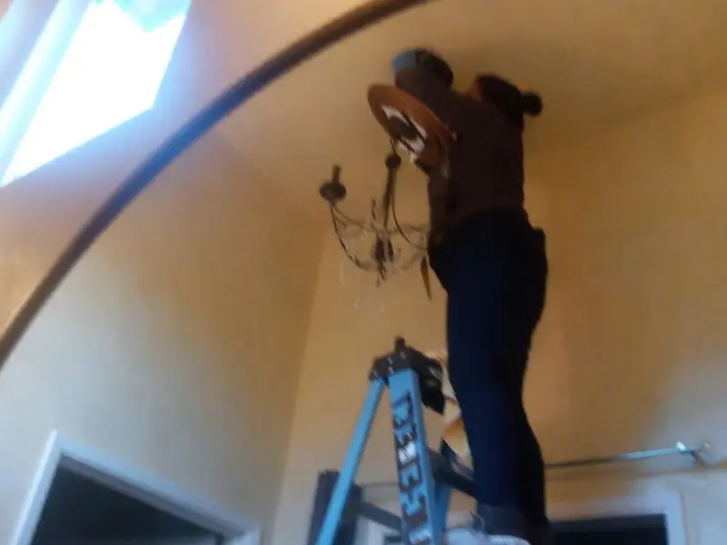 Electrician installing a chandelier in a Fridley residence